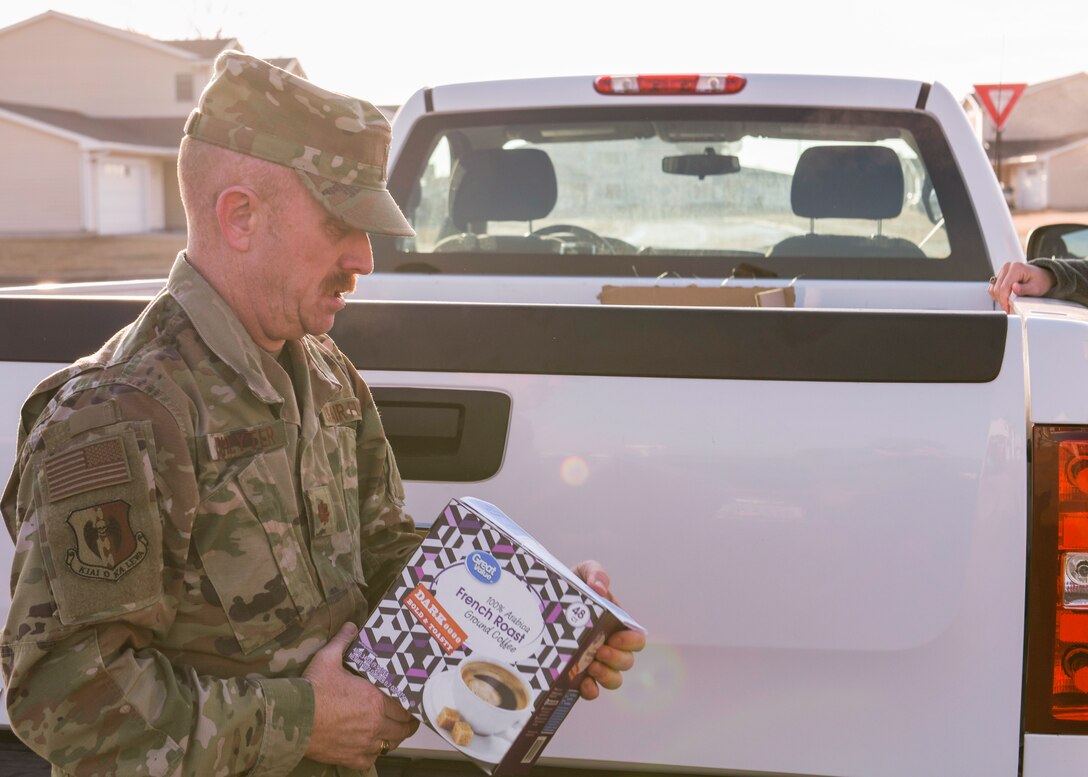 Maj. Jeffrey Lichlyter 5th Bomb Wing Chapel chaplain, holds a coffee box March 26, 2020, at Minot Air Force Base, North Dakota. Team Minot personnel donated coffee beans to Airmen and their families in need.