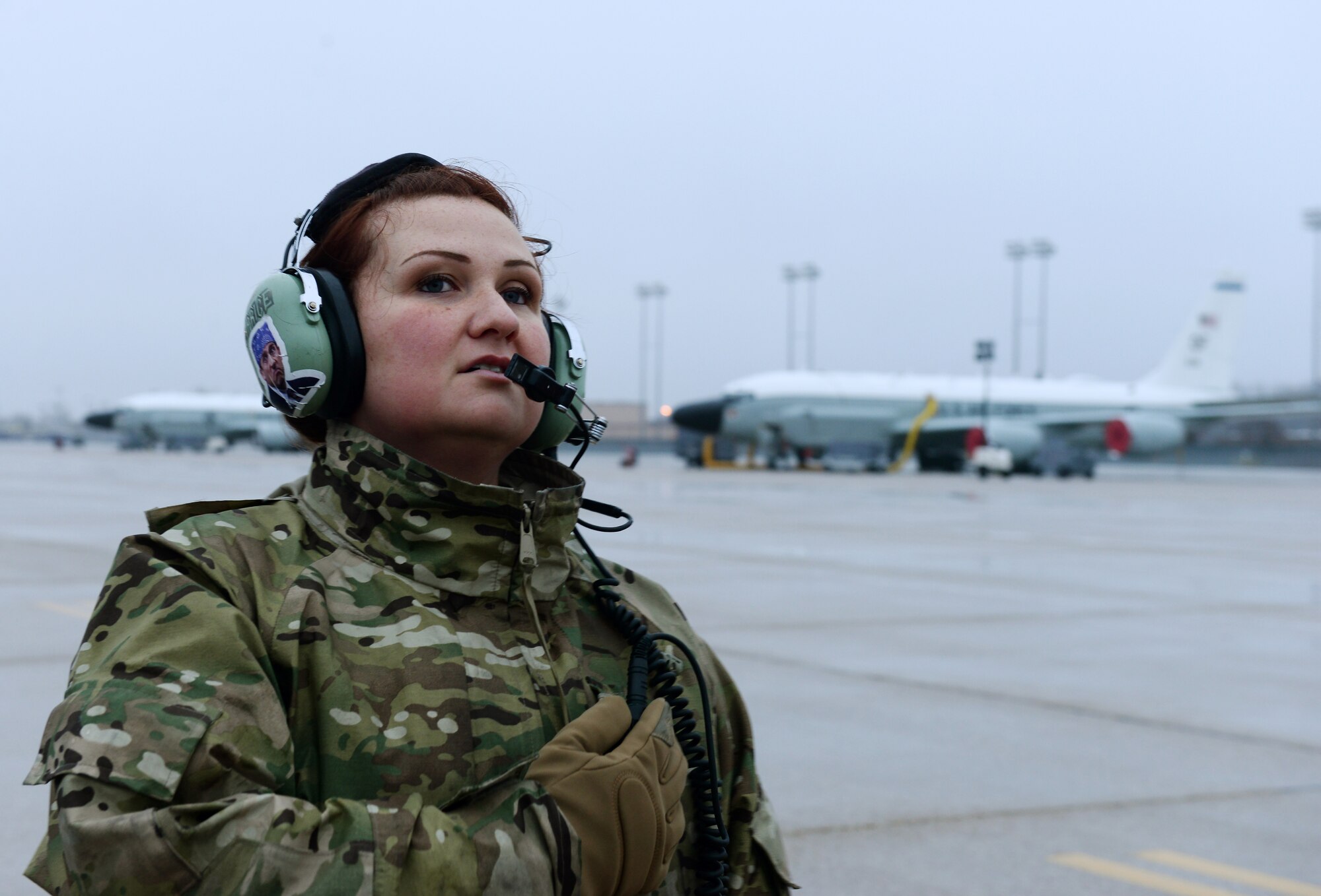 An Airman standing on the flightline listening to the pilot's instructions.