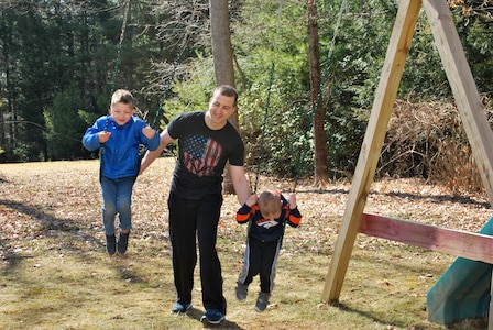 Staff Sgt. Andrew Menard, station commander, Southbridge, MA, pushes his sons on the backyard swing after a long day of recruiting virtually.