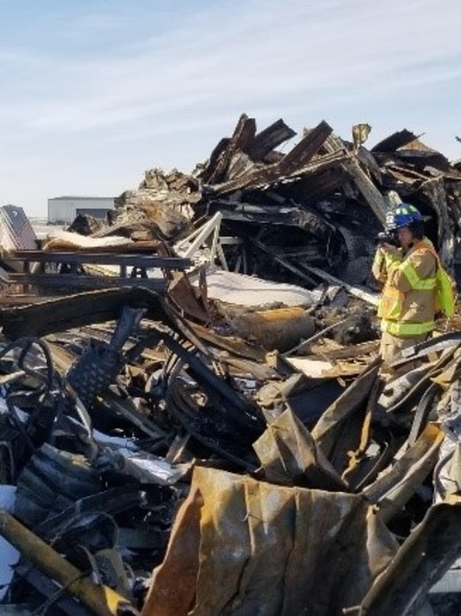On Dec. 28, 2019, a fire gutted a Strategic Air Command-era hangar on Miniot Air Force Base, N.D. Office of Special Investigations Detachment 813 and 2nd Field Investigations Squadron teamed with the Bureau of Alcohol, Tobacco, Firearms and Explosives to conduct the subsequent investigation. Here, Special Agent Andrew Weinzierl photographs scene conditions to help determine the origin and cause of the blaze resulting in a $7M loss to the Air Force. (Photo by Investigator Jesse Gomez, OSI Det. 813)