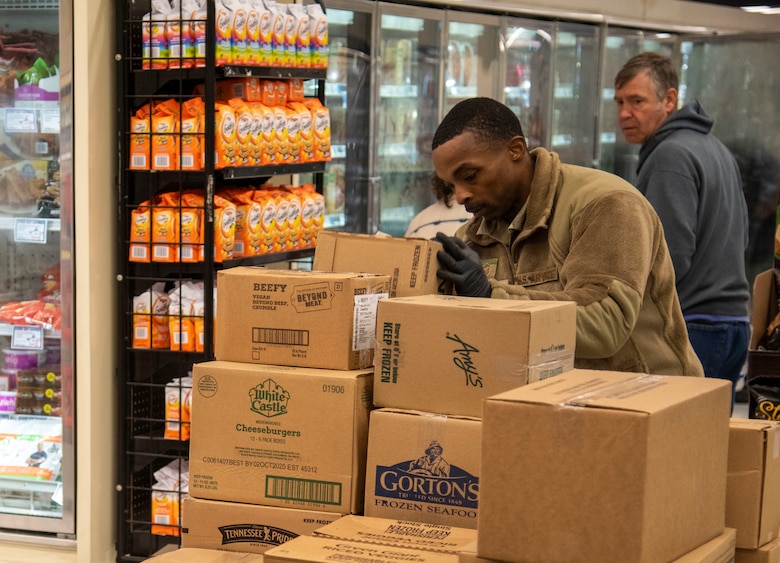 Master Sgt. Mauritius McCall, 436th Security Forces Squadron first sergeant, picks up a box before stocking shelves March 25, 2020, at Dover Air Force Base, Del. The Chiefs Group and first sergeants volunteered at the commissary checking IDs, assisting with social-distancing measures and stocking shelves to help mitigate the spread of COVID-19, reduce confusion and ensure Airmen and their families still had access to essential items. (U.S. Air Force photo by Airman 1st Class Jonathan Harding)