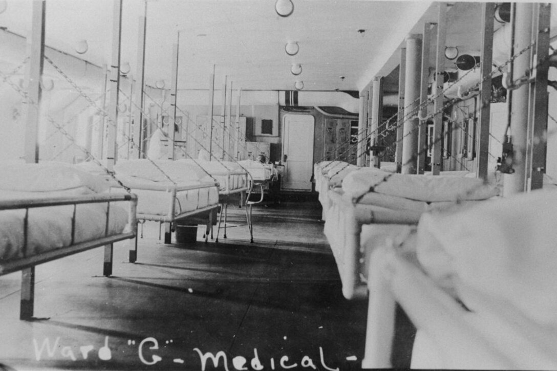 Hospital beds line two walls aboard a ship.