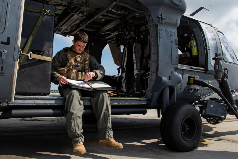 Photo of an Airman reviewing a preflight checklist.
