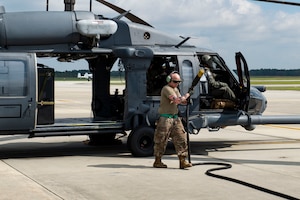 Photo of an Airman disconnecting a power cord from an HH-60G Pave Hawk.