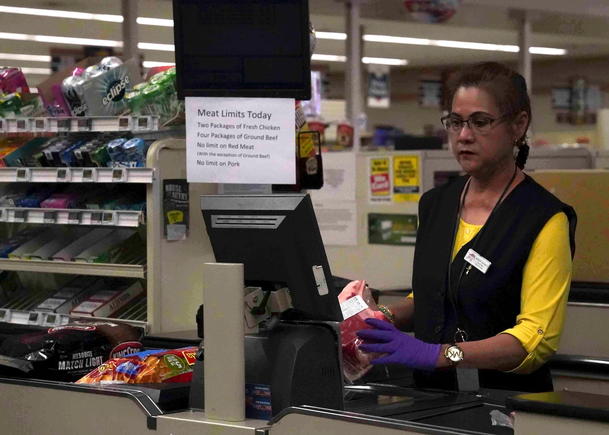 Amelia Camacho, a Defense Commissary Agency cashier, scans items at the commissary on Nellis Air Force Base, Nevada, March 24, 2020. Commissary workers continue to serve customers amid the COVID-19 pandemic while using personal protective equipment, such as gloves and face masks. (U.S. Air Force photo by Senior Airman Stephanie Gelardo)
