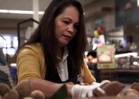 Maria Paddock, a Defense Exchange Agency produce store worker, restocks food in the commissary on Nellis Air Force Base, Nevada, March 24, 2020. The need to restock items throughout the day has increased as customers buy larger quantities of items during the COVID-19 pandemic. (U.S. Air Force photo by Senior Airman Stephanie Gelardo)