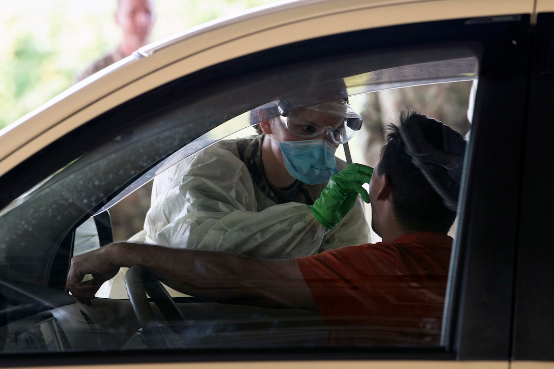 An airmen tests a person for the coronavirus.