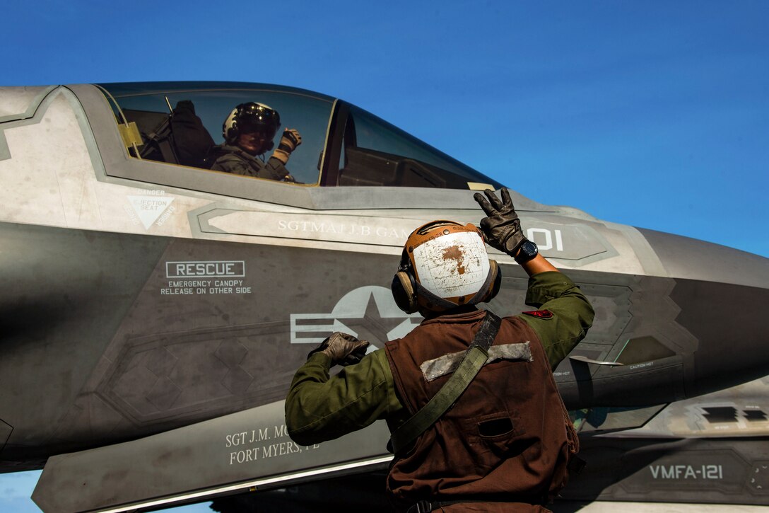 A Marine signals to a pilot.