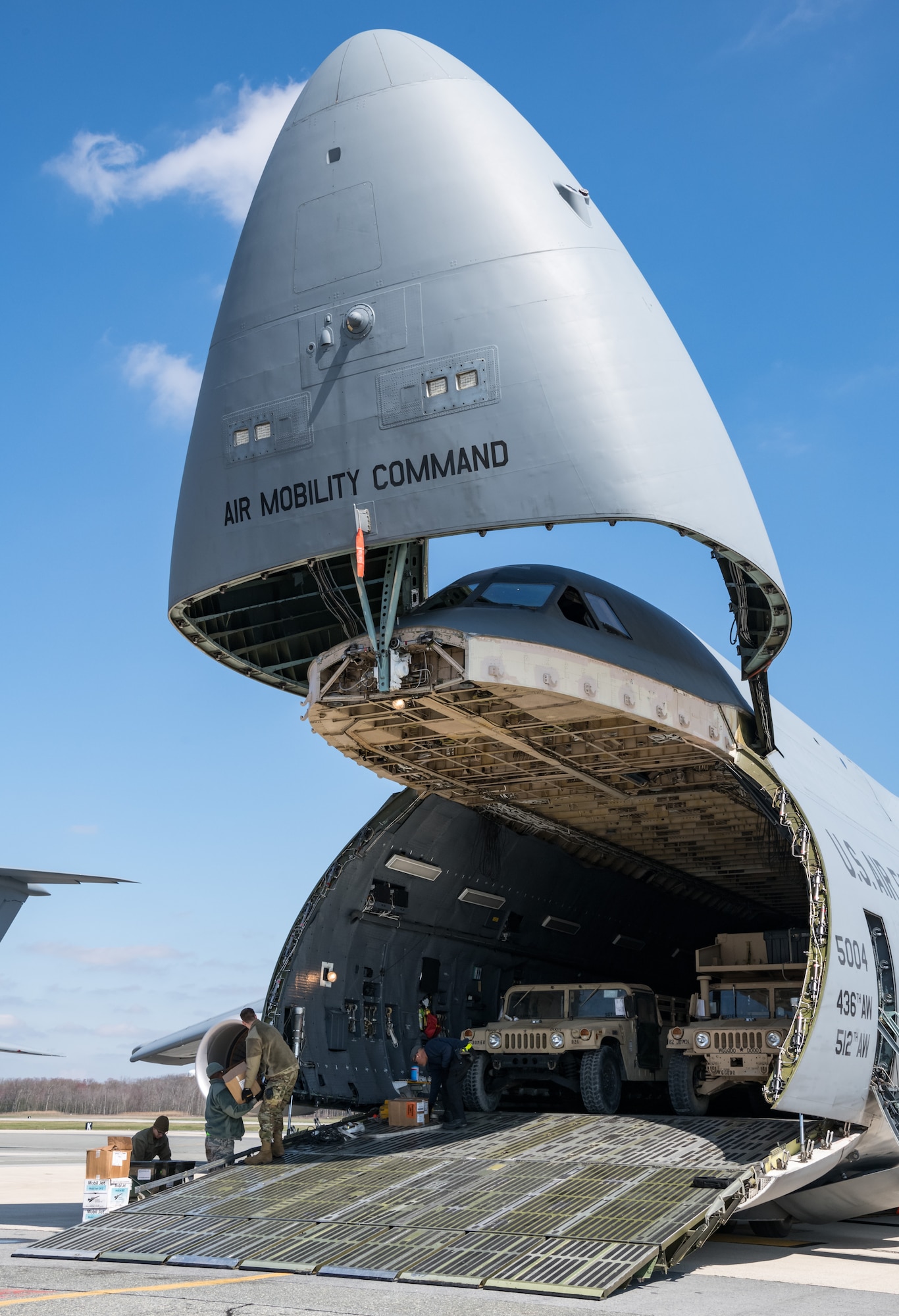A team of 436th Aerial Port Squadron personnel prepare to unload Humvees down the forward loading ramp of a C-5M Super Galaxy March 26, 2020, at Dover Air Force Base, Delaware. Numerous Humvees were off-loaded from the Super Galaxy as required airlift operations continued during the evolving COVID-19 pandemic. (U.S. Air Force photo by Roland Balik)