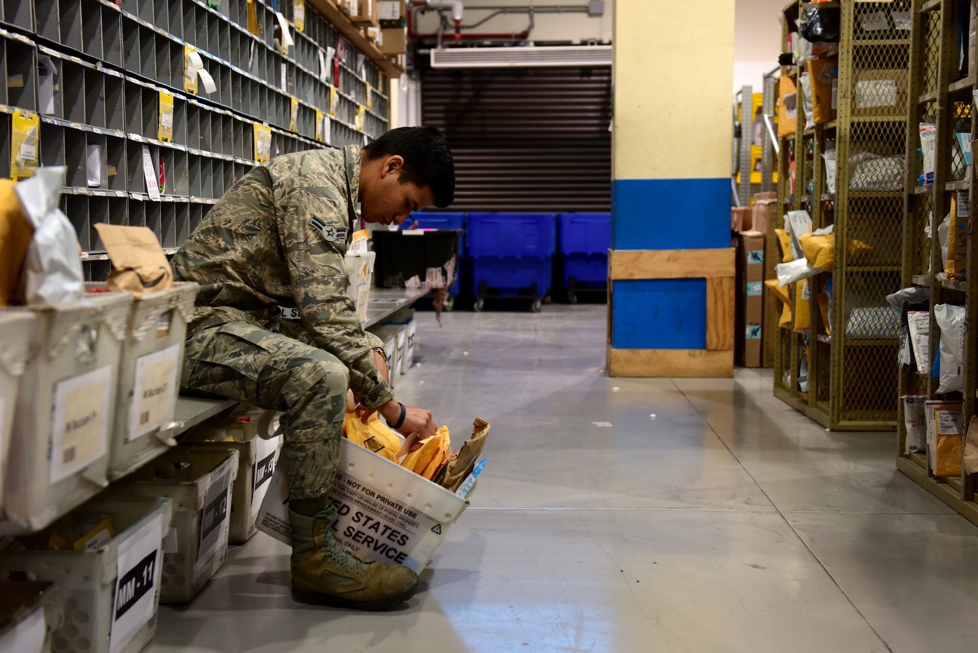 U.S. Air Force Airman 1st Class Daniel Young, 31st Force Support Squadron postal clerk, places labels onto packages at the Aviano Post Office, Aviano Air Base, Italy, March 25, 2020. After sorting, each package receives a label denoting the recipient and its location on the shelf. (U.S. Air Force photo by Staff Sgt. Kelsey Tucker)