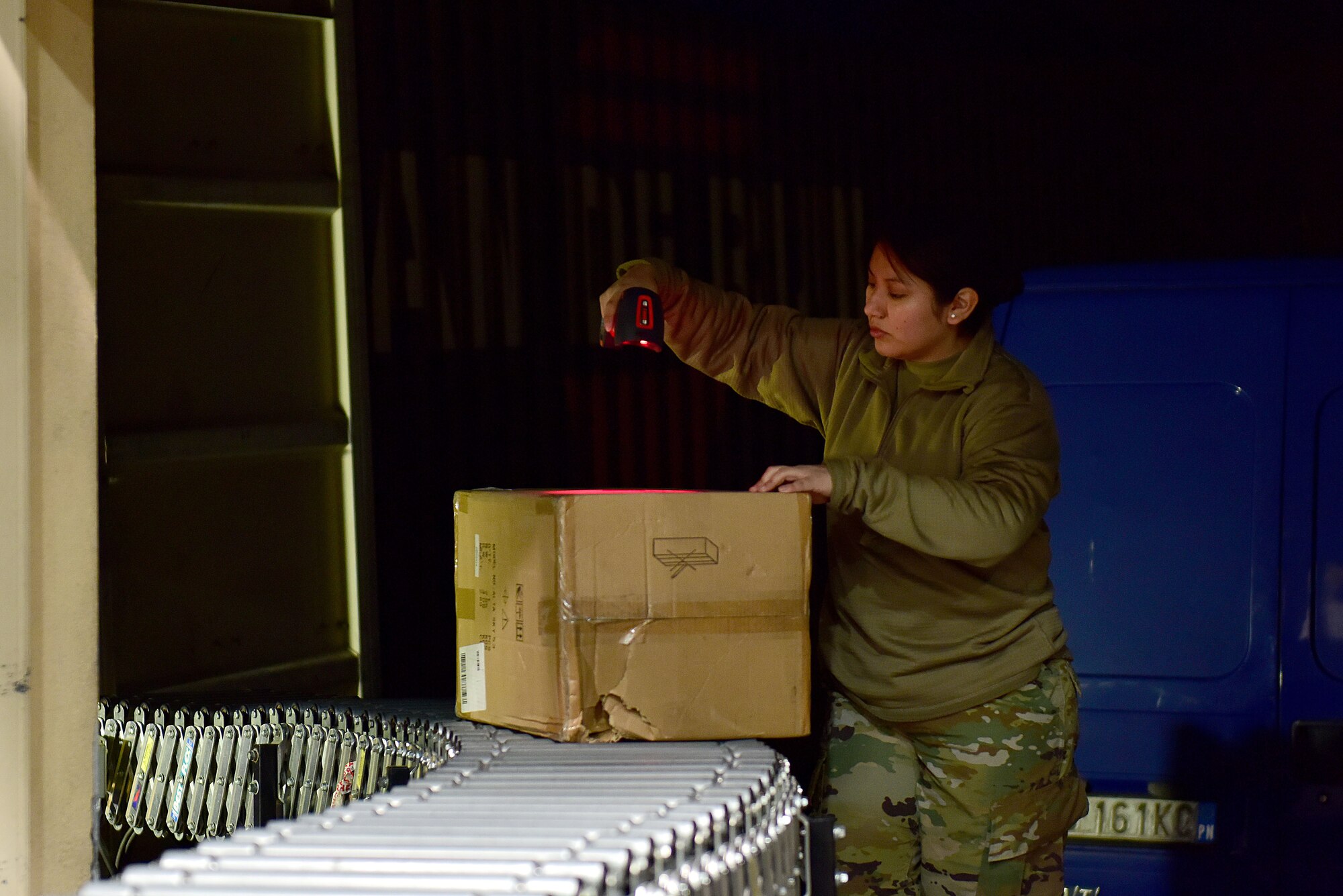 U.S. Air Force Staff Sgt. Eddith Guaman, 31st Force Support Squadron postal supervisor, scans an incoming package at the Aviano Post Office, Aviano Air Base, Italy, March 25, 2020. After unloading packages from the trucks, post office Airmen scan them into their system, sort them, and then either deliver them to members’ mailboxes or inform them via email that they have a package ready for pickup. (U.S. Air Force photo by Staff Sgt. Kelsey Tucker)