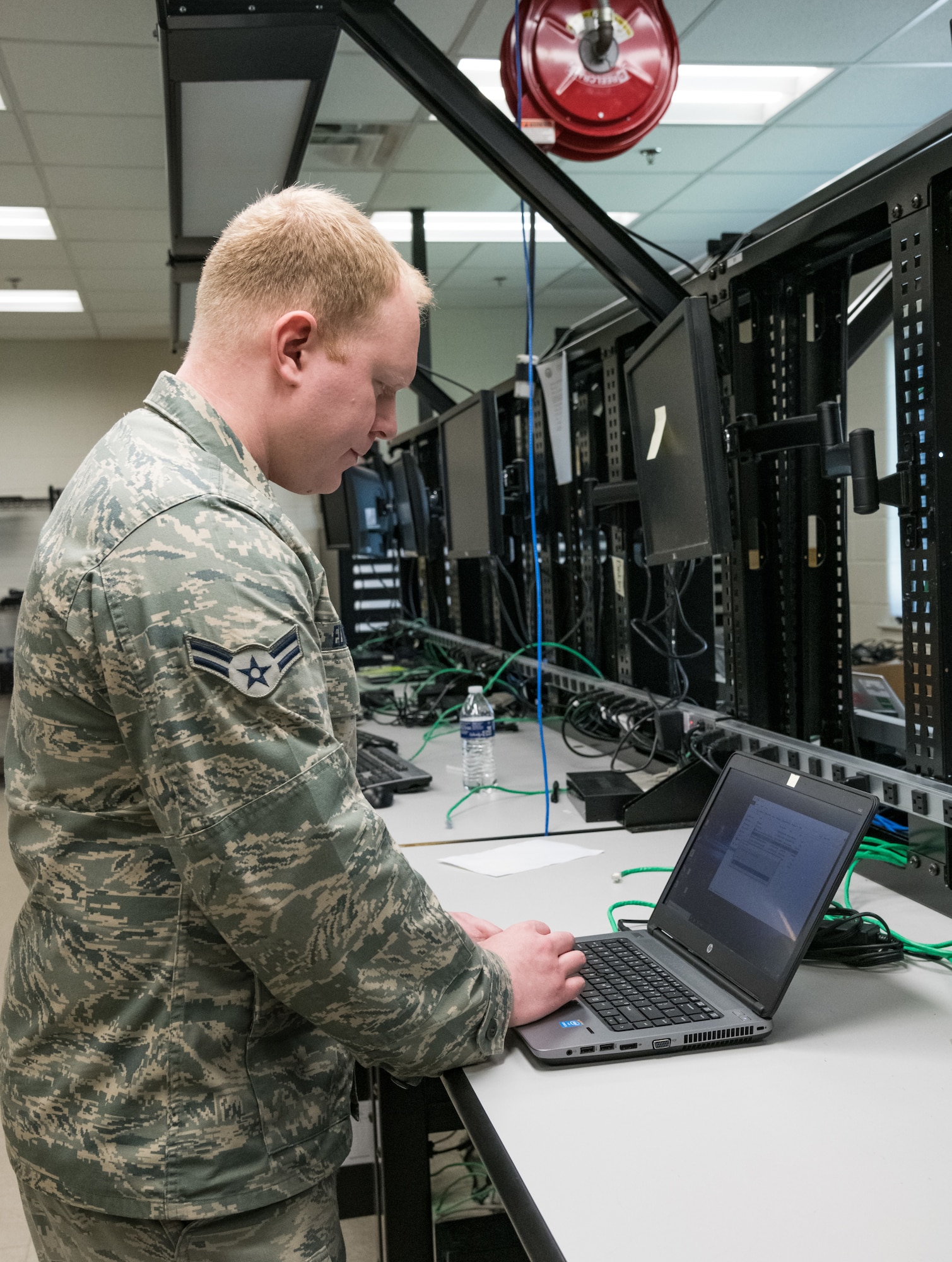 Airman 1st Class Joshua Edmonds, 436th Communications Squadron client systems technician, configures a laptop on the consolidated work bench, March 26, 2020, on Dover Air Force Base, Delaware. Client systems technicians worked on numerous computers due to increasing teleworking requirements in an effort to mitigate the spread of COVID-19. (U.S. Air Force photo by Roland Balik)