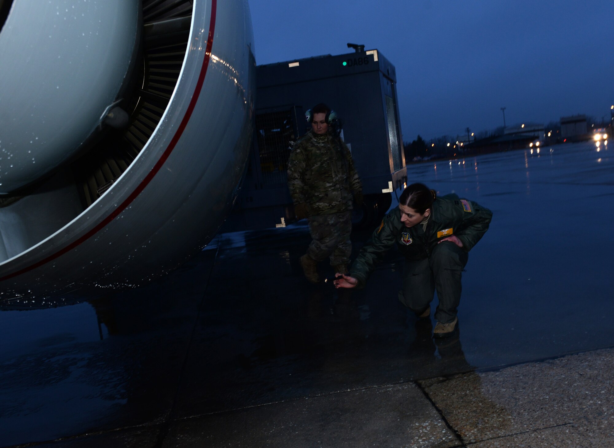 Airmen with a flashlight in her hand looks over an aircraft before departure.