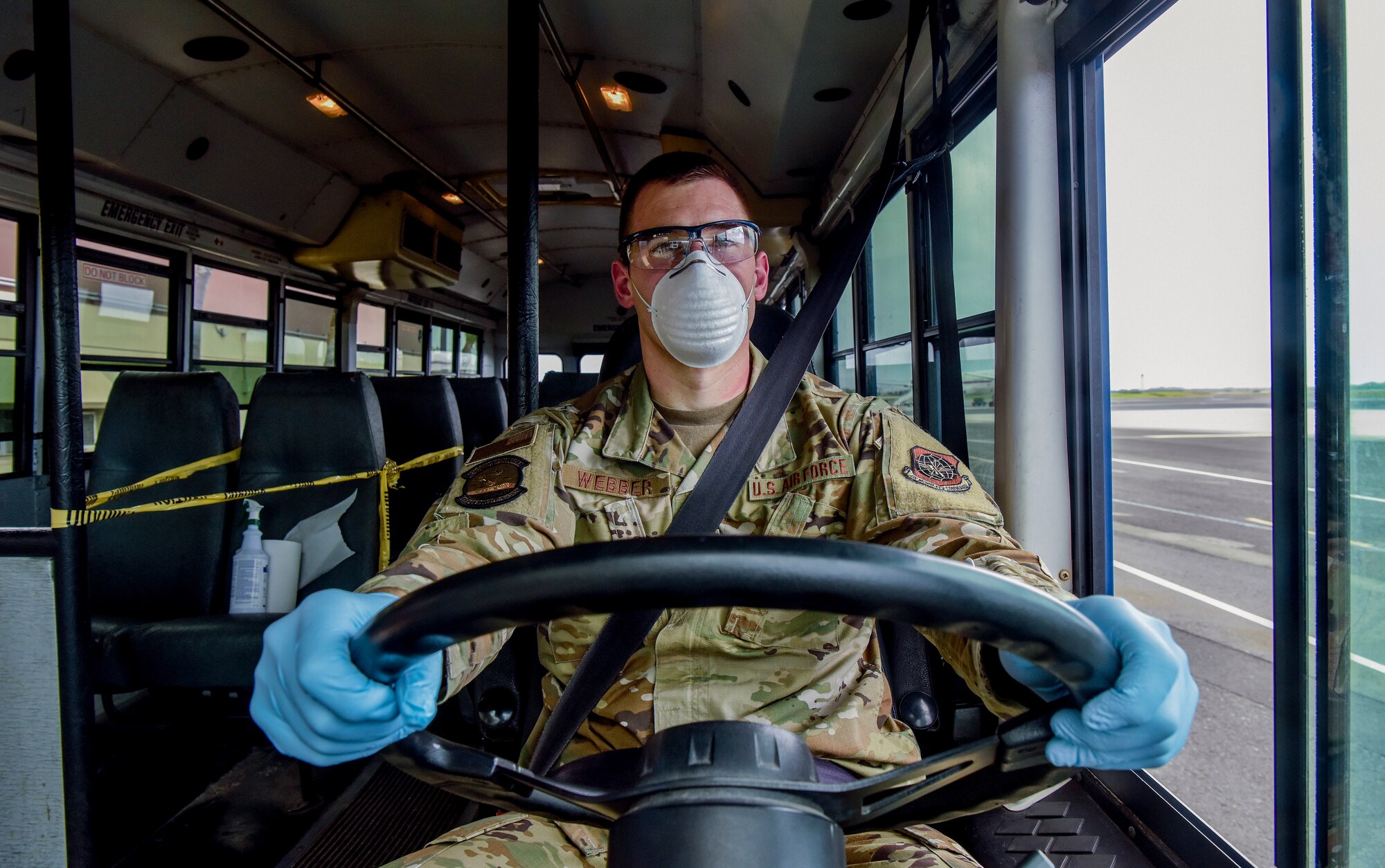 U.S. Air Force Staff Sgt. Colton Webber, 735th Air Mobility Squadron passenger terminal shift supervisor,    dones proper personal protective equipment before transporting passengers to and from the aircraft at Joint Base Pearl Harbor-Hickam, Hawaii, March 25, 2020.
The 735th AMS blocked off the first two rows of seats behind the driver to adhere to the social distancing preventive measures put out by the Center for Disease Control and Prevention. 

(U.S. Air Force photo by Tech. Sgt. Anthony Nelson Jr. )