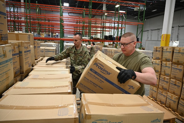 (From left) U.S. Air Force Tech. Sgt. Bradly Tuthill and U.S. Air Force Master Sgt. Richard Malloy, both ground transportation specialists with the 175the Logistics Readiness Squadron, prepare and load boxes of medical supplies and equipment March 19, 2020, at the Maryland Strategic National Stockpile location. All assets provided were prioritized for health care workers and hospitals in response to the COVID-19 pandemic. (U.S. Air National Guard photo by Master Sgt. Christopher Schepers)