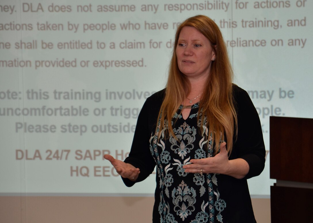 Robin Rogers in front of a slide screen giving training