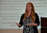 Robin Rogers in front of a slide screen giving training