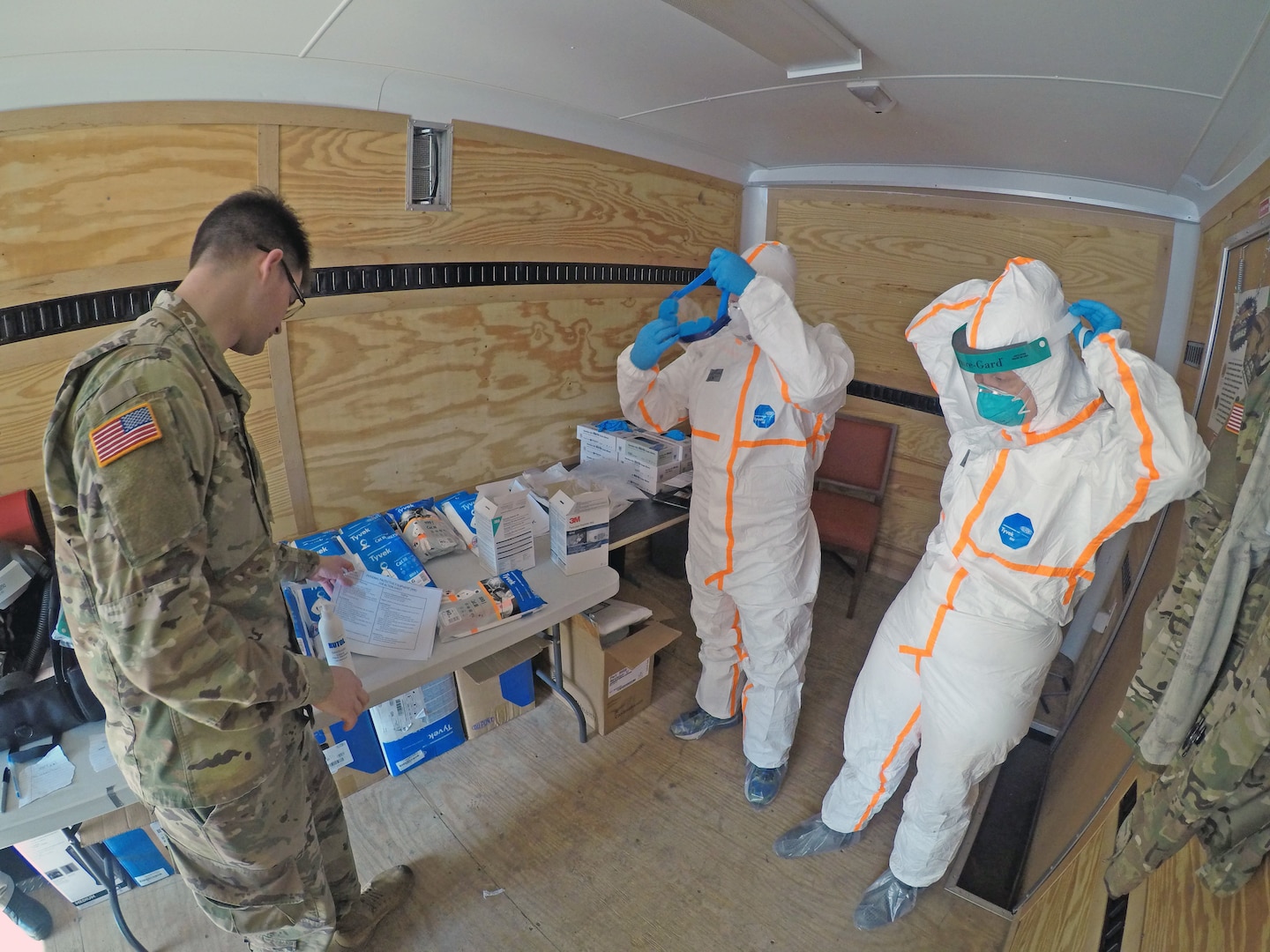 The California Army National Guard’s Pfc. Michael Daggi of the California National Guard Medical Detachment instructs California Emergency Medical Service Authority (EMSA) staff members on properly applying personal protective equipment March 27 at a San Mateo County, California, COVID-19 treatment facility.