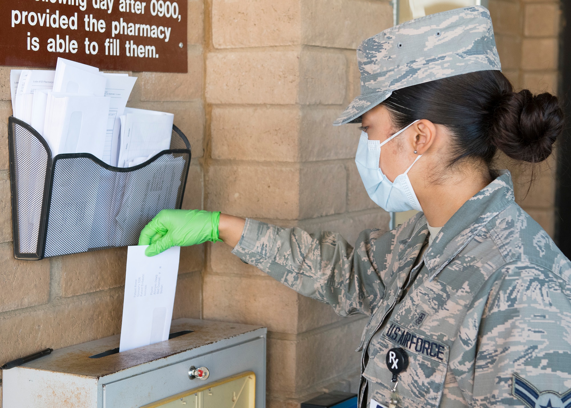 Airman 1st Class Erika Tolentino, 56th Medical Group pharmacy technician, places a prescription order in a drop off box March 26, 2020, at Luke Air Force Base, Ariz.
