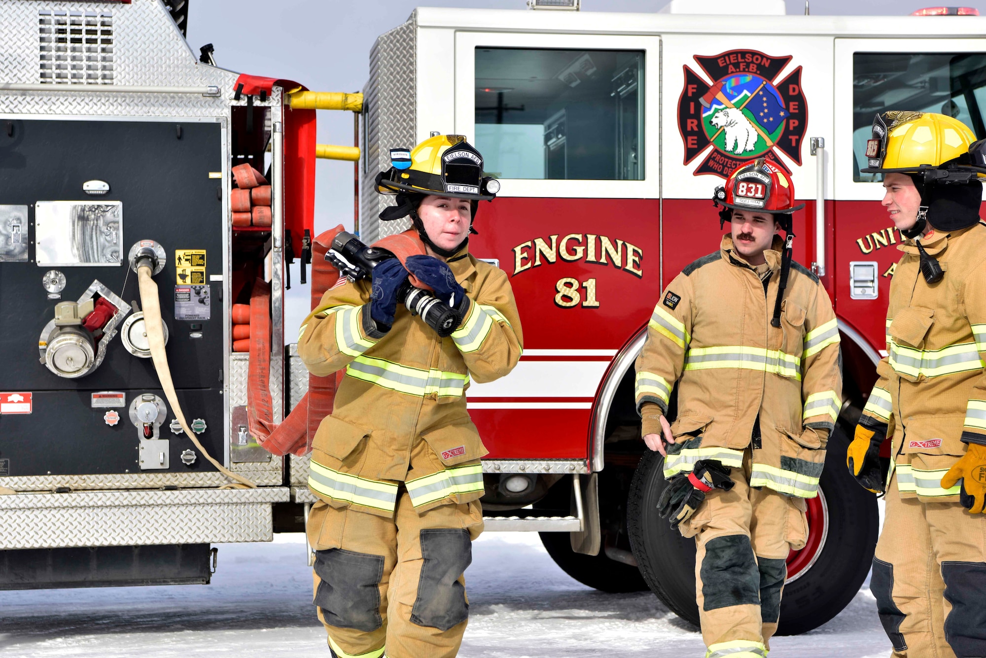 Airman Lily Lane, a 354th Civil Engineer Squadron firefighter, pulls a hose from a fire truck as part of a training exercise on Eielson Air Force Base, Alaska, March 26, 2020. Eielson firefighters conduct routine walk-throughs of installation facilities to ensure a more rapid response in case of an emergency situation. (U.S. Air Force photo by Senior Airman Beaux Hebert)