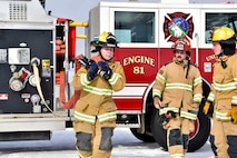 Airman Lily Lane, a 354th Civil Engineer Squadron firefighter, pulls a hose from a fire truck as part of a training exercise on Eielson Air Force Base, Alaska, March 26, 2020. Eielson firefighters conduct routine walk-throughs of installation facilities to ensure a more rapid response in case of an emergency situation. (U.S. Air Force photo by Senior Airman Beaux Hebert)