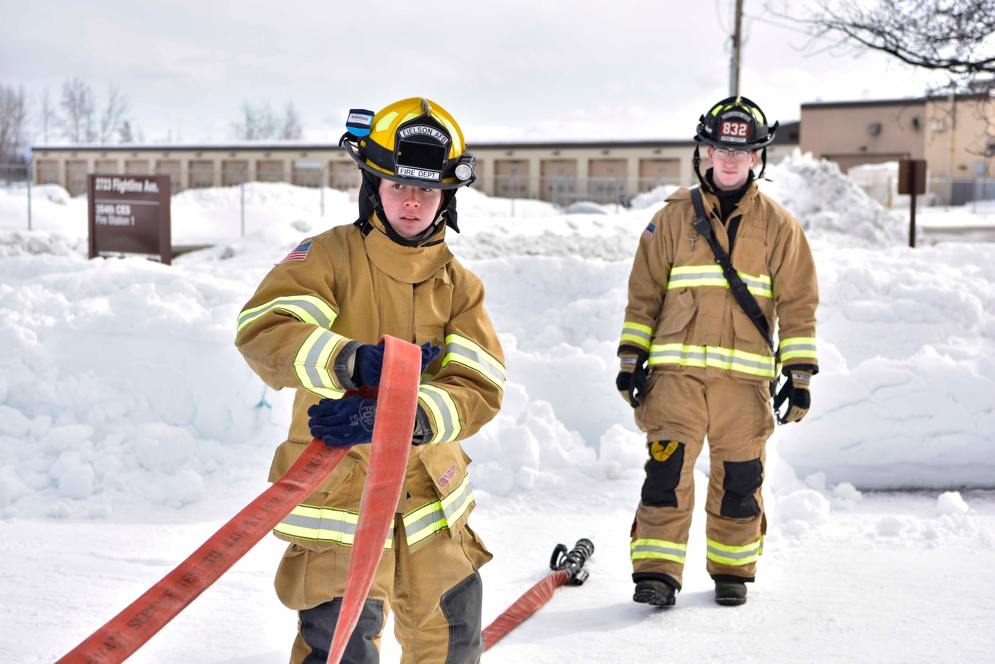 Airman Lily Lane, a 354th Civil Engineer Squadron firefighter, pulls a hose from a fire truck during a training exercise on Eielson Air Force Base, Alaska, March 26, 2020. Eielson firefighters train for multiple types of situations such as cold-weather response, forest fire containment, structure and vehicle fires, as well as medical emergencies. (U.S. Air Force photo by Senior Airman Beaux Hebert)