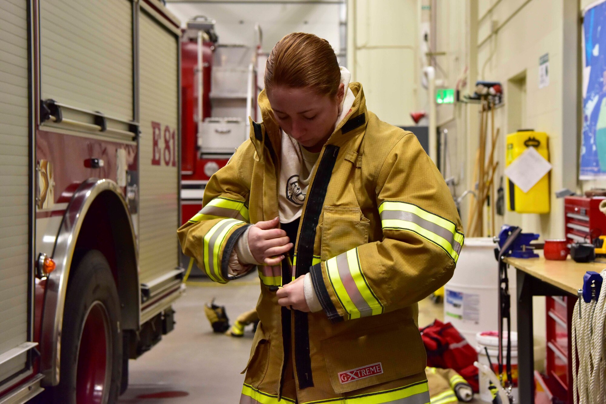 Airman Lily Lane, a 354th Civil Engineer Squadron firefighter, dons fire protection equipment during a training exercise on Eielson Air Force Base, Alaska, March 26, 2020. In 2019, the Eielson fire department responded to approximately 500 calls, the majority being structural and medical. (U.S. Air Force photo by Senior Airman Beaux Hebert)