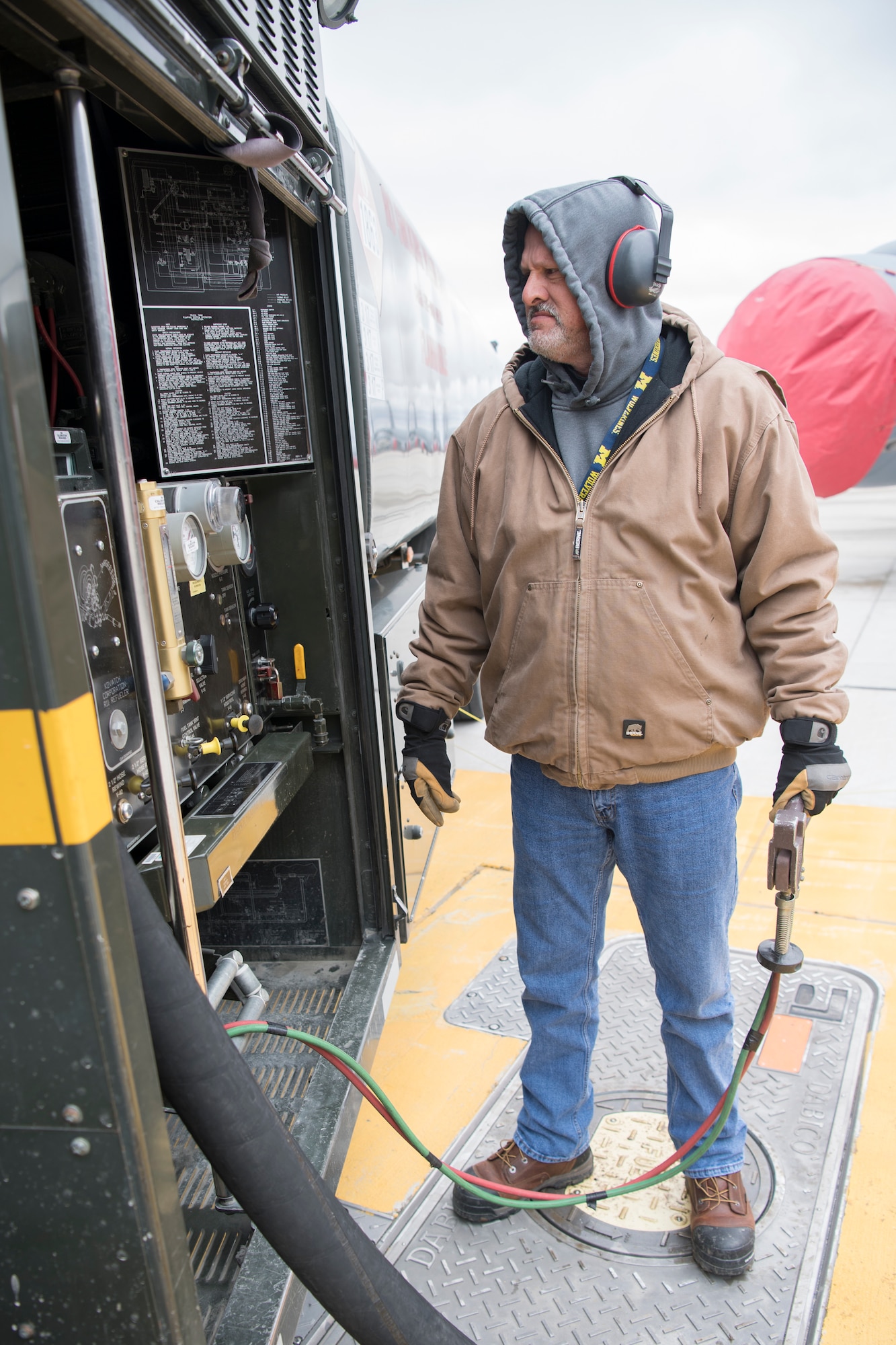 Danny Bowlin, a Grissom contractor, holds a fuel shut-off switch while a KC-135R Stratotanker receives fuel at Grissom Air Reserve Base, Indiana March 20, 2020. The tanker along with three other tankers are preparing to deploy to Southwest Asia in support of Air Force Central Command combat operations. (U.S. Air Force photo/Master Sgt. Ben Mota)