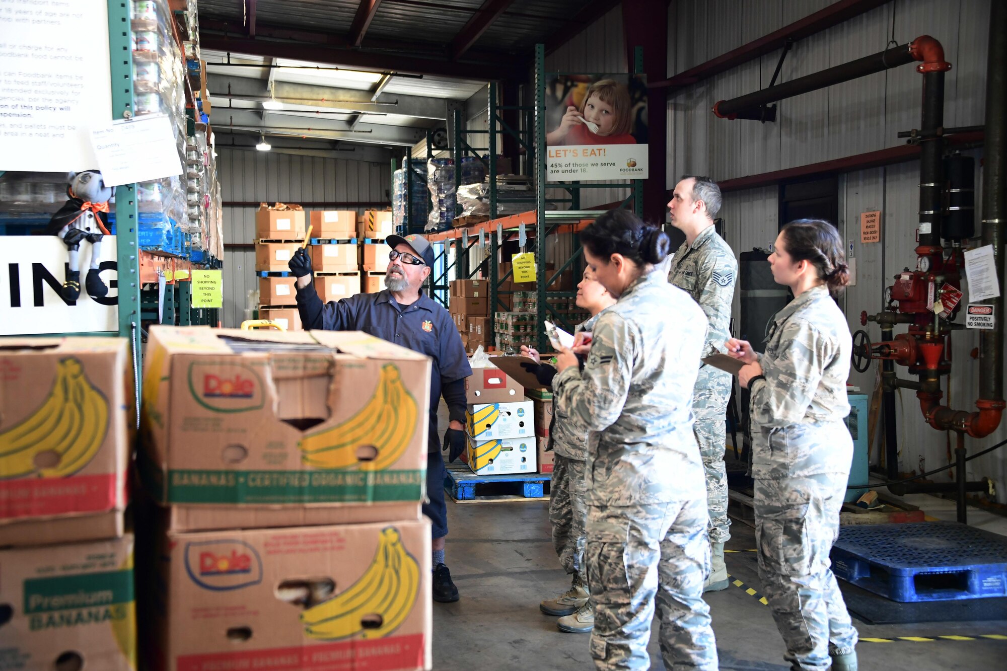 A photo of California Air National Guardsmen receiving instructions on inventorying food by a Foodbank Santa Barbara employee.