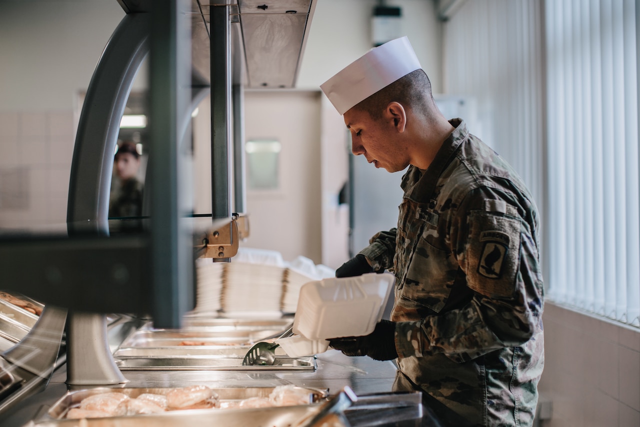 A soldier works in a cafeteria.