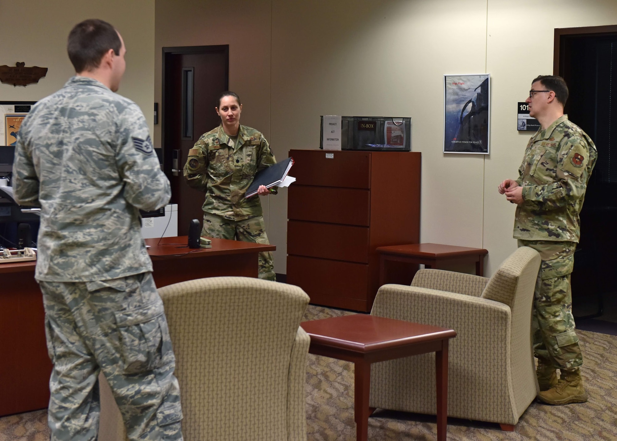 Individuals in the Norma Brown Building on Goodfellow Air Force Base, Texas, practice social distancing during their morning meeting on March 30, 2020. In an effort to slow the spread of COVID-19, meetings are being held in wider spaces or are being conducted through teleconferencing. (U.S. Air Force photo by Senior Airman Seraiah Wolf)