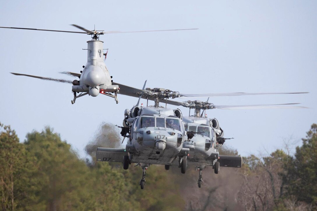 Three military aircraft fly in the sky.