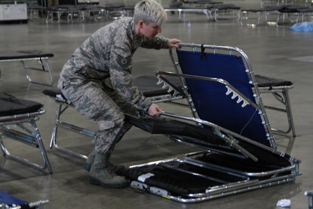 A Photo of U.S. Air National Guard Tech. Sgt. Becky Jensen setting up a medical bed inside of the Los Angeles Convention Center.