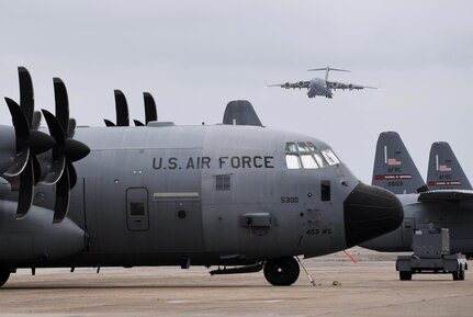 A C-17 airplane taxis into a parking spot