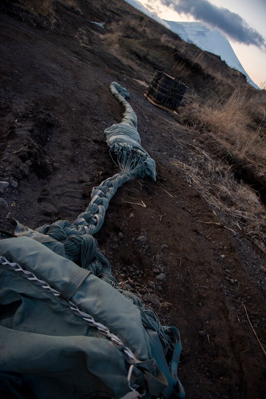 A parachute is prepared to be stowed into a recovery bag at the Combined Arms Training Center, Camp Fuji, Japan