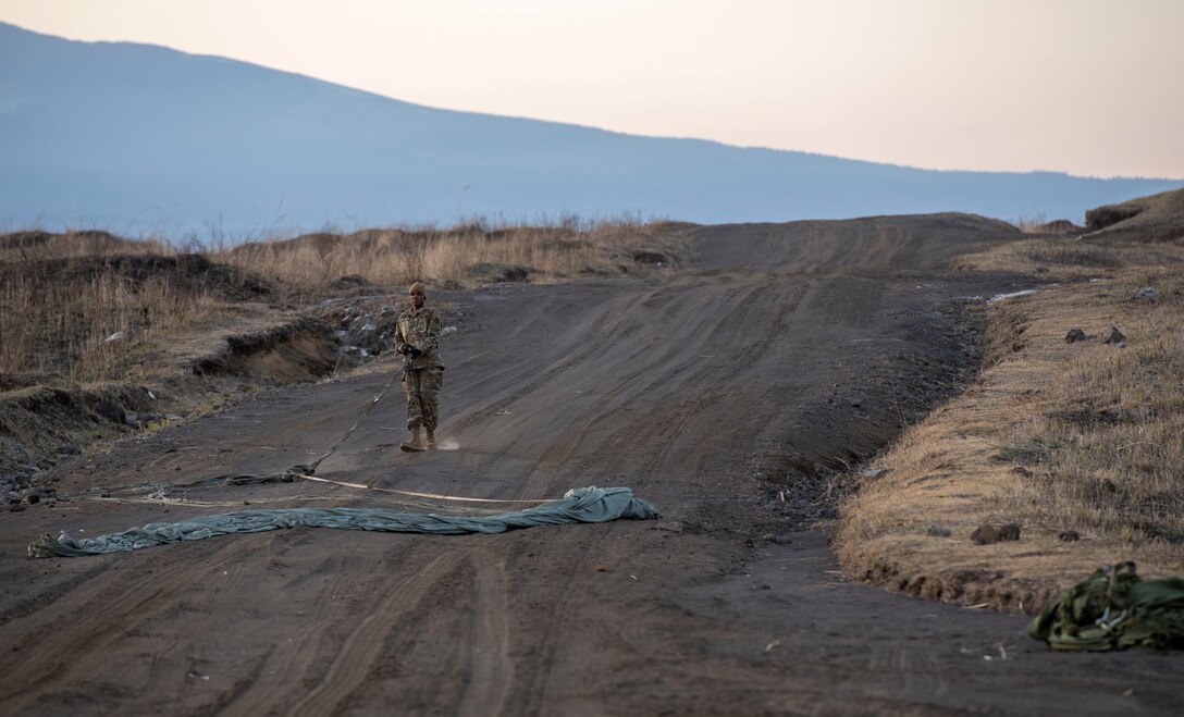 Airman 1st Class Jalen Riley, 374th Logistics Readiness Squadron combat mobility flight technician, prepares a canopy and suspension lines before stowing the parachute inside a recovery bag