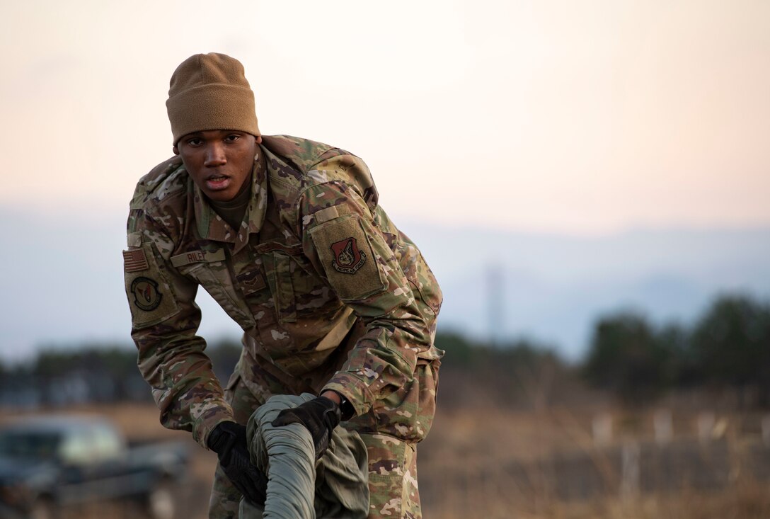 Airman 1st Class Jalen Riley, 374th Logistics Readiness Squadron combat mobility flight technician, twists canopy and suspension lines before stowing the parachute inside a recovery bag