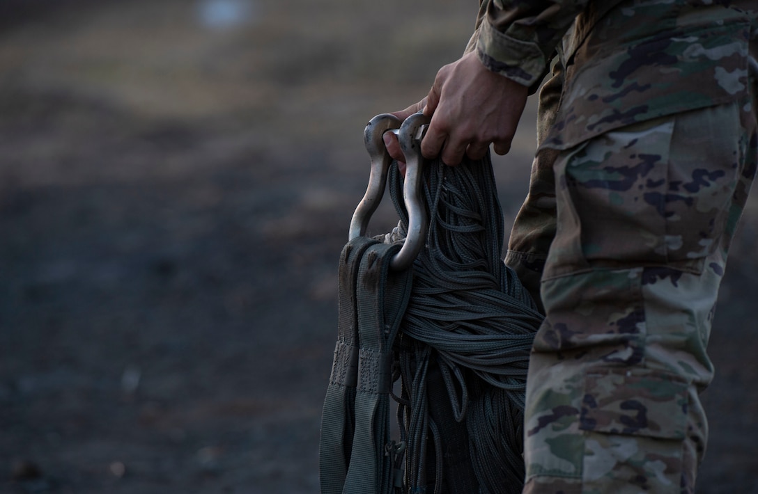 Staff Sgt. Nicholas Adkins, 374th Logistics Readiness Squadron combat mobility flight supervisor, folds parachute suspension lines before stowing the parachute inside a recovery bag