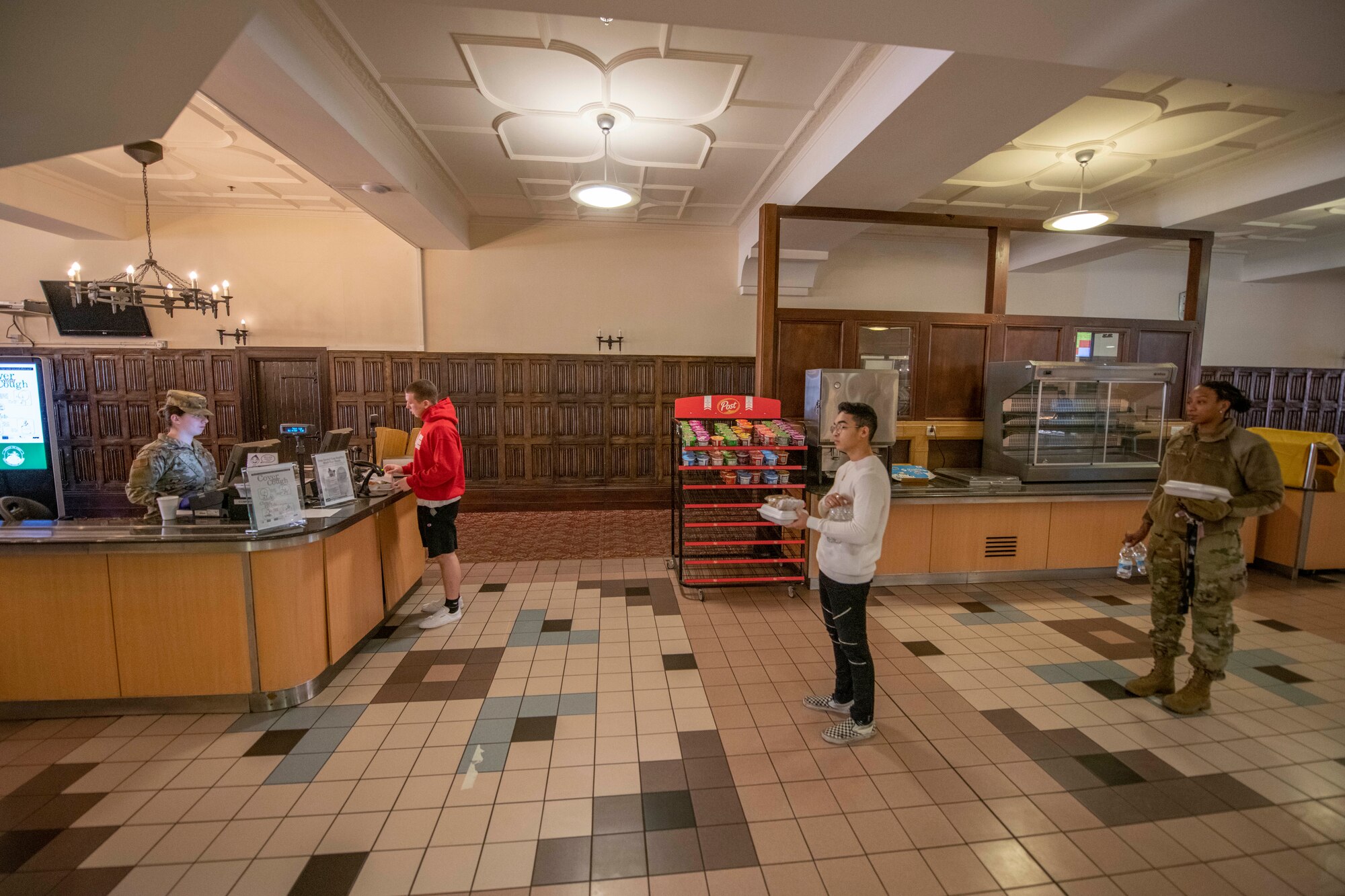 Mildenhall Airmen maintain a distance of six feet while waiting in line at the dining facility to prevent the spread of COVID-19 on RAF Mildenhall, England, March 25, 2020. Such practices have been implemented across the base to prevent the spread of the disease. (U.S. Air Force photo by Staff Sgt. Luke Milano)