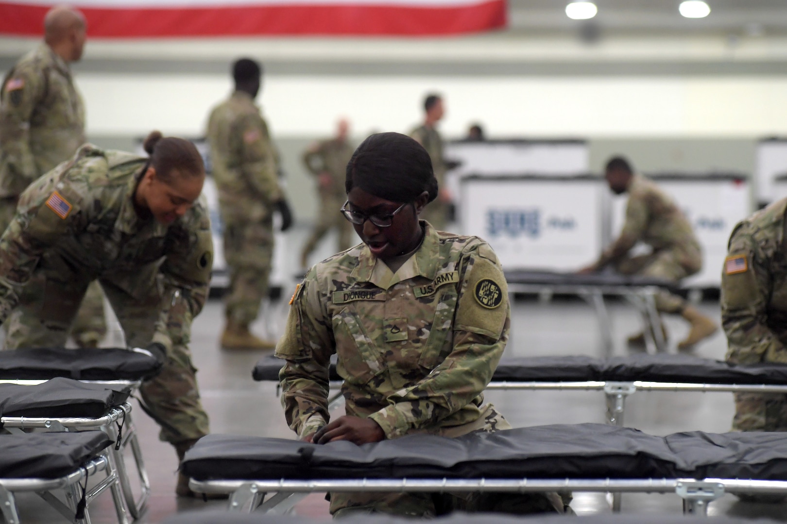 Army Pfc. NDeye Diongue, assigned to the Maryland Army National Guard’s 1297th Support Battalion, assembles a cot and bedding as she and other Soldiers set up a federal medical station in the Baltimore Convention CenterMarch 28, 2020. The station was set up to alleviate possible overcrowding at area hospitals as a result of the COVID-19 outbreak.