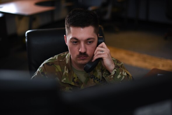 Staff Sgt. Jordan Field, 22nd Operation Support Squadron weather forecaster, answers the phone March 26, 2020, at McConnell Air Force Base, Kansas. Field continually monitors weather severity and wind speeds to ensure everything from aircraft flights to outdoor physical fitness tests are permitted. (U.S. Air Force photo by Senior Airman Alexi Bosarge)