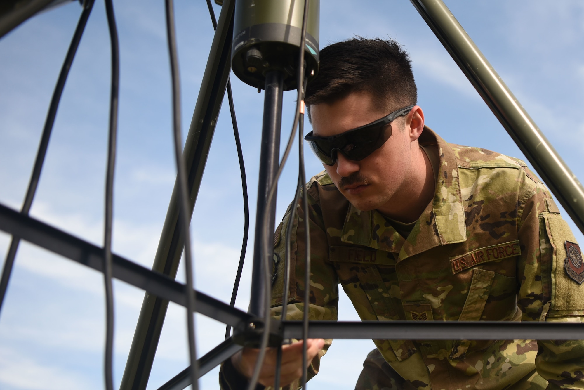 Staff Sgt.Jordan Field, 22nd Operation Support Squadron weather forecaster, checks the level of the tactical meteorological observing system March 26, 2020, at McConnell Air Force Base, Kansas. Field used a bullseye level to ensure the TMQ-53 is level in order to get accurate readings on the wind direction. The TMQ-53 is a portable, automated weather system that makes observations on all types of weather in five second intervals. This information is then sent to a laptop where a forecast can be developed. (U.S. Air Force photo by Senior Airman Alexi Bosarge)