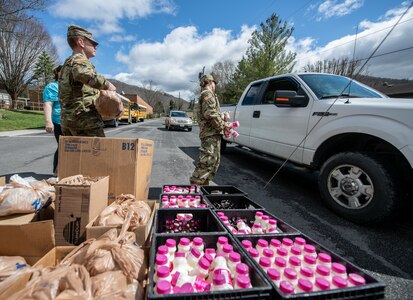 Members of the West Virginia National Guard help volunteers package and deliver meals for more than 3,600 school-age students throughout Greenbrier County during the COVID-19 pandemic outbreak, March 25, 2020, in Lewisburg, West Virginia.