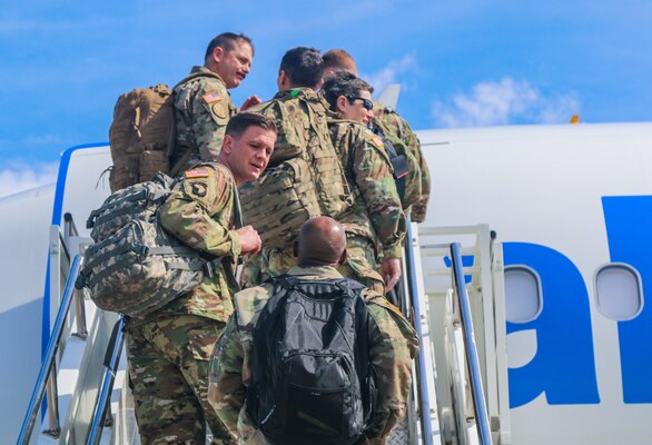 Soldiers board a commercial aircraft.