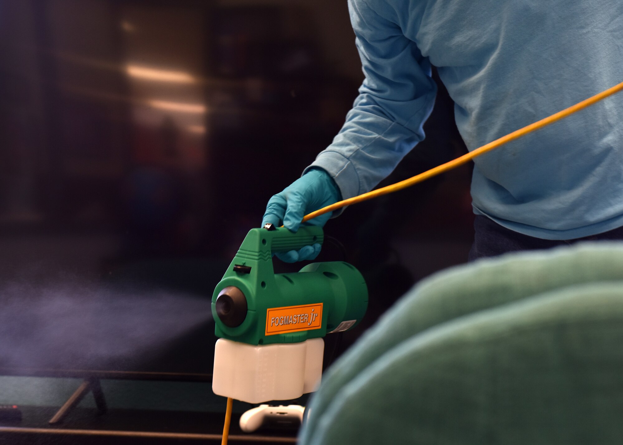 17th Civil Engineer Squadron Pest Controller Walter Miller uses a fog machine to disperse a mystified disinfectant at the school-age program building on March 30, 2020. Individual organizations are responsible for daily disinfecting of the areas, the fogging is a service that CES offers as an extra precaution. (U.S. Air Force photo by Senior Airman Seraiah Wolf)