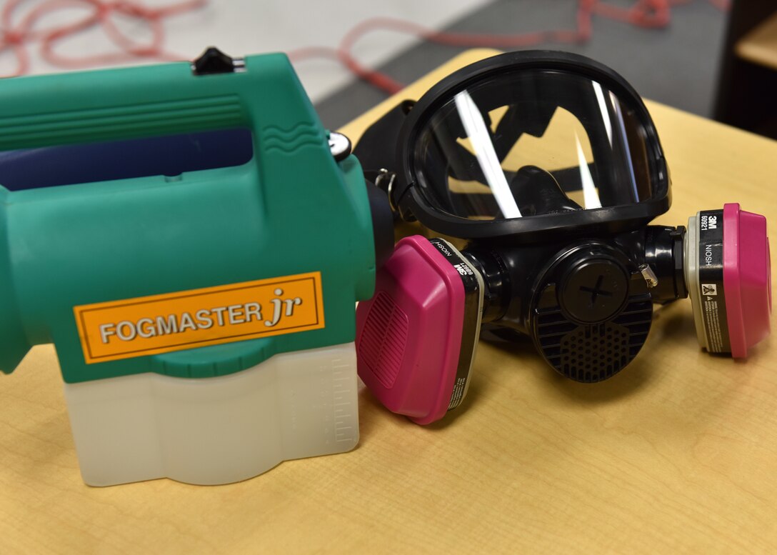 A mask and fogging machine sit on a table before use at the school-age program building on Goodfellow Air Force Base, Texas, March 30, 2020. The chemical used in the machine for disinfecting the rooms is certified as safe to use without the masks but 17th Civil Engineer Squadron members are taking every precaution. (U.S. Air Force photo by Senior Airman Seraiah Wolf)