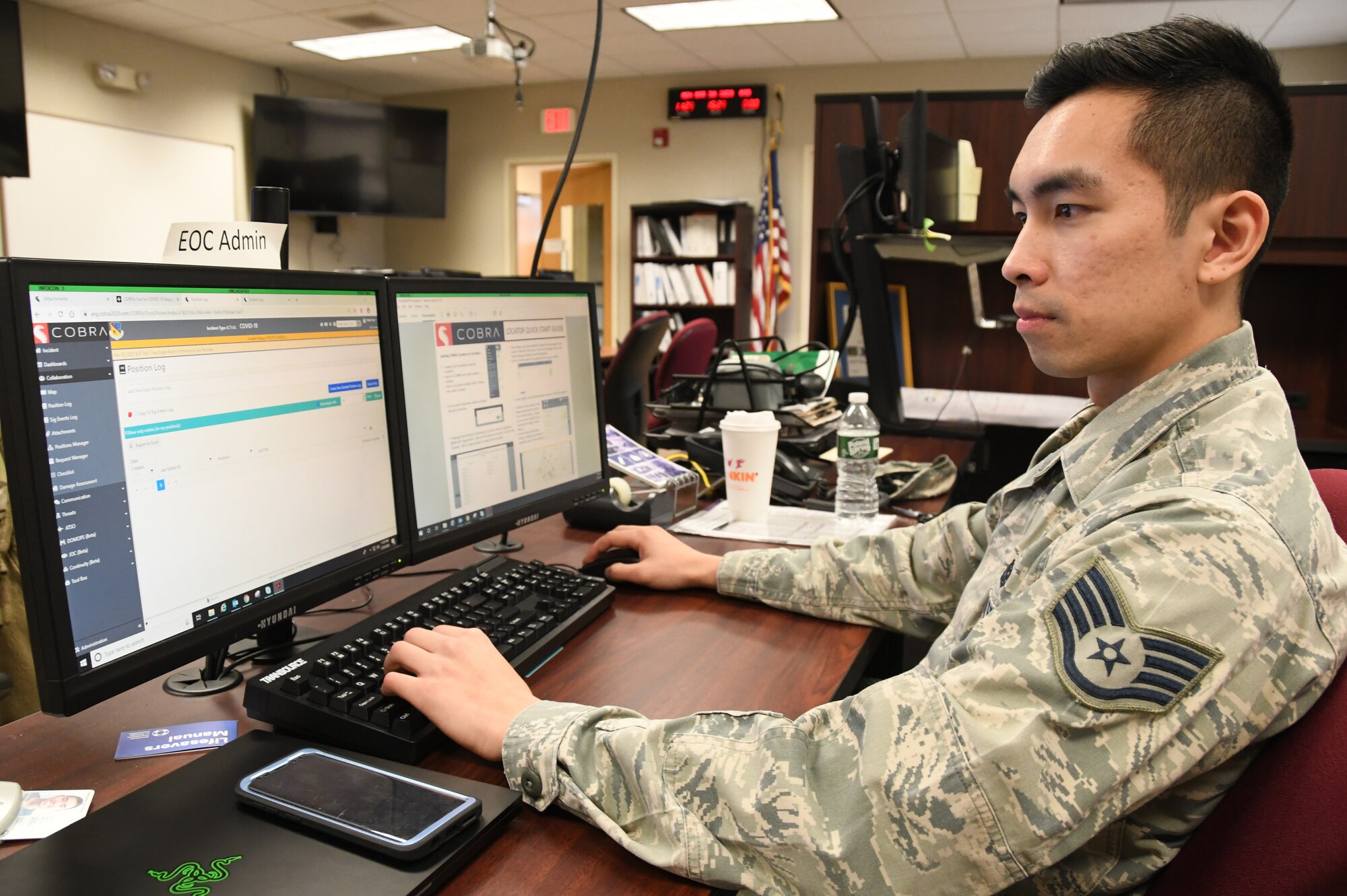 Staff Sgt. Tran Thinh, 104th Fighter Wing Emergency Management, monitors and coordinates with the Emergency Operation Center on critical information requests in response to COVID-19, March 30, 2020. Trinh serves in his community as an Air National Guard member and is an engineering student at the University of Connecticut. (U.S. Air National Guard Photo by Senior Master Sgt. Julie Avey)