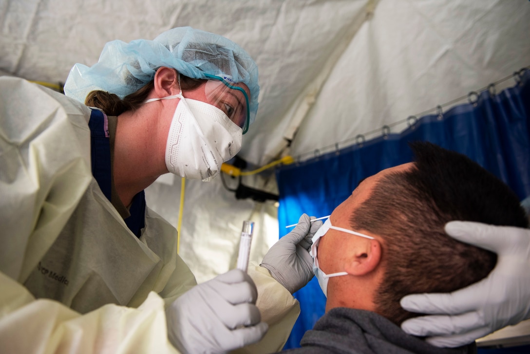 An airman tests a patient for COVID-19.