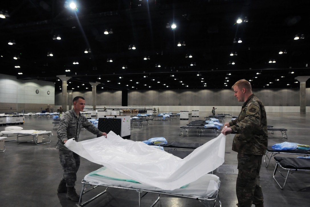 Airmen set up beds for a quarantine area.
