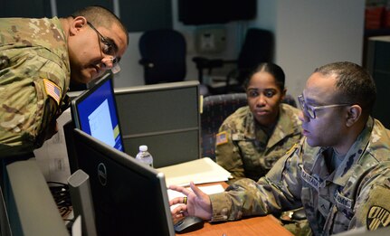 Members of the New York Army National Guard discuss procedures at the Coronavirus Hotline call center in Hawthorne, N.Y., March 16, 2020. The New York State Department of Health established a toll-free Coronavirus Hotline (1-888-364-3065).